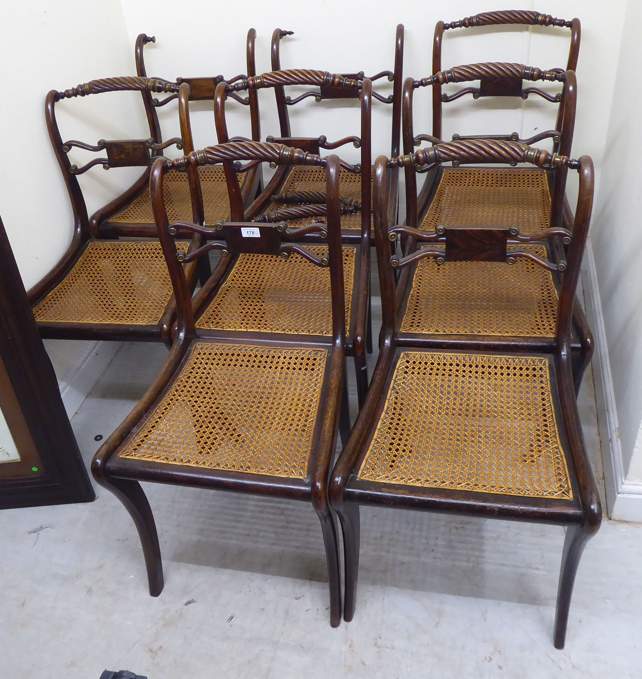 A set of eight Regency faux rosewood stained beech framed scroll back dining chairs,