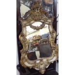 A late 19thC mirror, in an ornate gilt gesso frame,