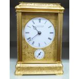 An early 20thC decoratively cast and gilded metal cased carriage timepiece with bevelled glass