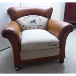 A Charleston Polo studded tan hide and cream coloured fabric upholstered, enclosed armchair,