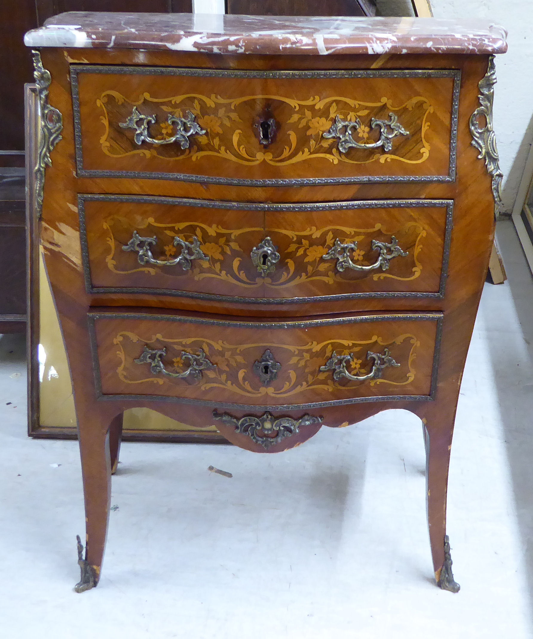 A late 19thC Louis XV design kingwood and marquetry bombe front commode with a mottled marble top,