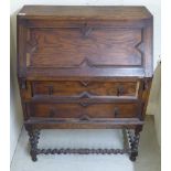 A 1930s oak bureau with a fall flap, over two long drawers,