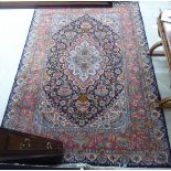 A Persian carpet profusely decorated with vases and flora on a dark blue ground 76'' x 110''