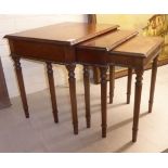 A nesting set of three modern mahogany occasional tables, raised on turned,