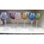 A set of six hock glasses, each with a different coloured,