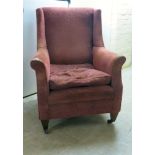 An early 20thC red textured, patterned fabric upholstered armchair,