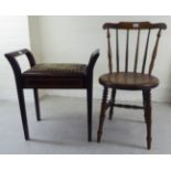 An early 20thC beech framed kitchen chair with a curved, spindled back and solid circular seat,