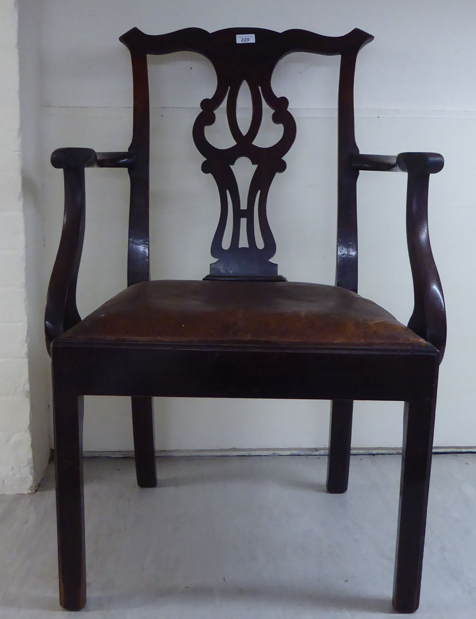 An early 19thC Chippendale inspired mahogany framed elbow chair with a yoke crest, pierced splat,