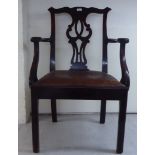 An early 19thC Chippendale inspired mahogany framed elbow chair with a yoke crest, pierced splat,