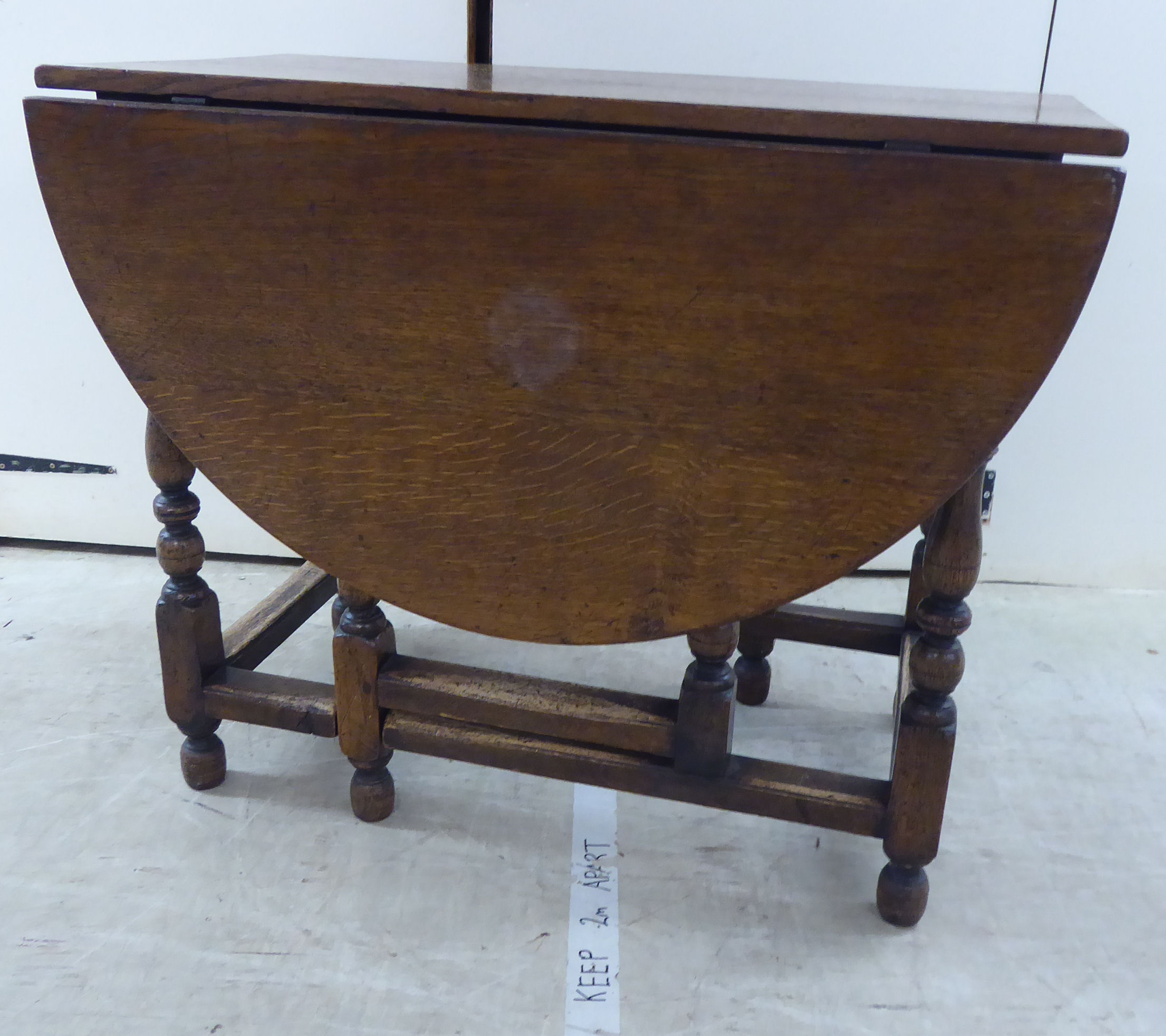 A modern Jacobean design oak dining table with fall flaps,