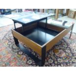 A 1980s (possibly Harrods) coffee table, the tinted black glass top with a rise-and-fall action,