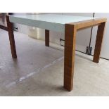 A vintage design dining table, the glass top raised on a teak finished end and legs 30''h 51.