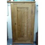 An early 20thC waxed pine cupboard, enclosed by a full height, panelled door 89''h 35.