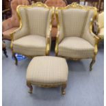 A pair of 20thC reproductions of French carved, gilded, showwood framed, wingback armchairs,