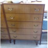 A 1970s teak finished five drawer dressing chest, raised on square,