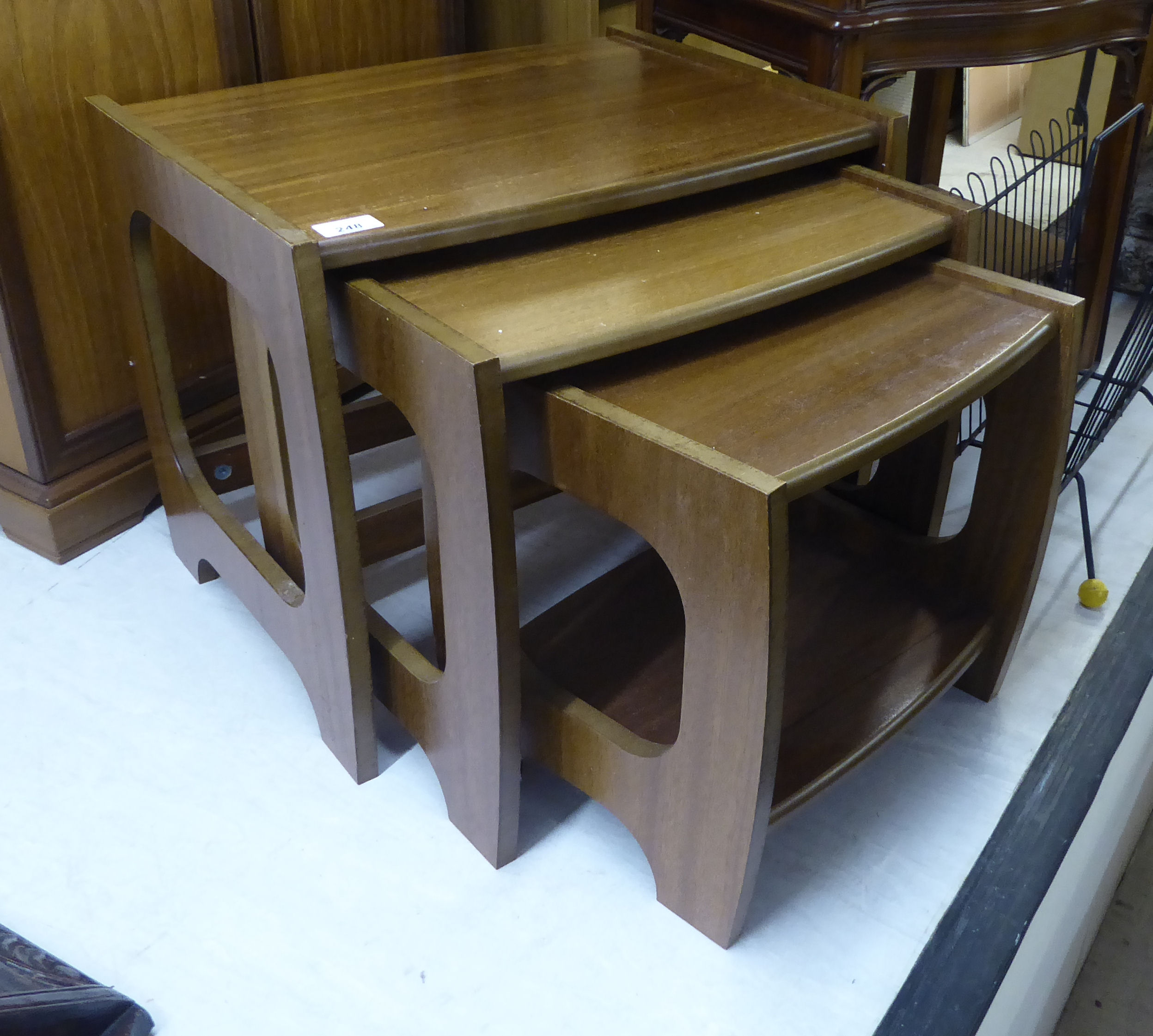 A modern Danish nesting set of three teak occasional tables, raised on cut-out ends largest 16.
