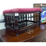 A 1930s stained beech framed footstool, upholstered in braided maroon fabric,