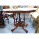 A late Victorian walnut breakfast table, the oval top elevated on five pillars,