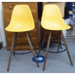 A pair of 'retro' design barstools, the moulded lemon coloured plastic seats raised on tapered,