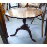 A 1930s mahogany coffee table, the piecrust bordered top over a vase turned column,