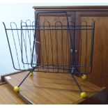 A 1970s black painted metal wire framed magazine rack,