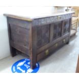 An 18thC tri-panelled oak coffer with straight sides, a carved crest rail and front panels,