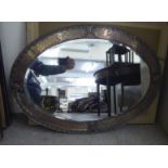 An Arts & Crafts oval mirror,