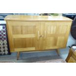An Ercol pale coloured elm and beech sideboard, the top having round corners,