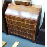 A modern figured yewwood finished bureau, the fall flap enclosing a fitted interior,