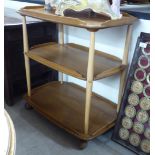 An Ercol beech and elm galleried, three tier tea trolley,