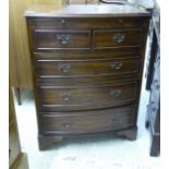 A modern mahogany finished bow front dressing chest with a brushing slide and two short/three long