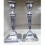 A pair of Edwardian loaded silver candlesticks,