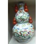 An early 20thC Japanese porcelain double gourd shaped vase, surmounted by five smaller vases,