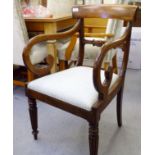 A Regency mahogany framed open arm chair with swept, open arms and a drop-in seat, raised on turned,