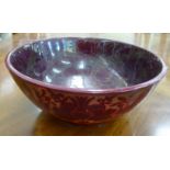 A Bernard Moore floral decorated red lustre footed pottery bowl bears painted and impressed marks