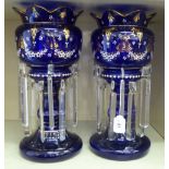 A pair of Edwardian gilded and overpainted midnight blue glass lustre vases with castellated rims