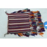 An Afghan saddle rug with tassled ends 25'' x 27'' CA