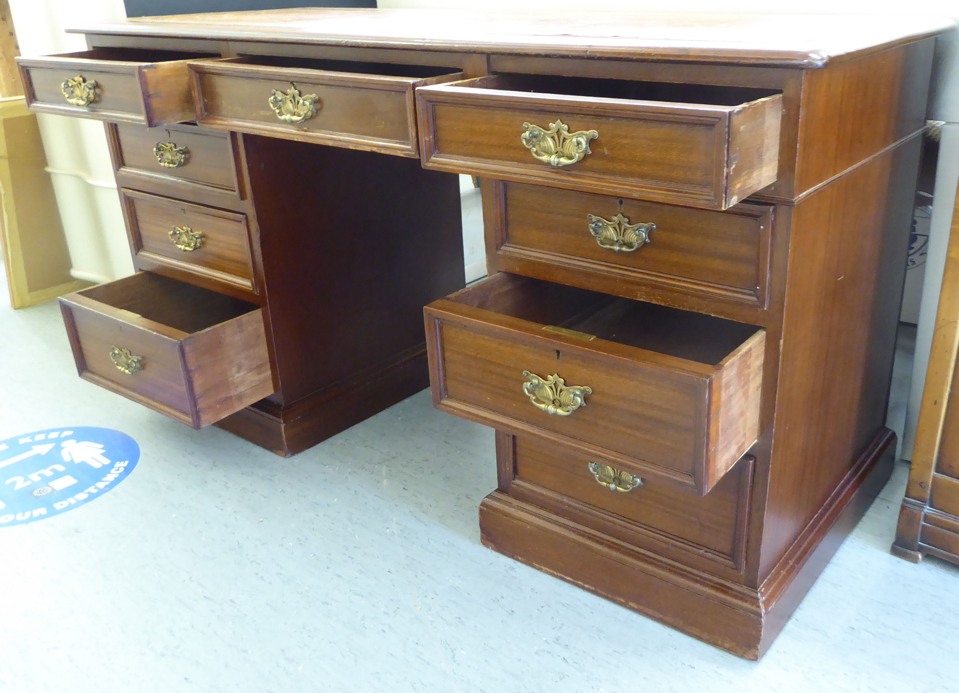 An early 20thC mahogany desk, the top set with a tooled brown hide scriber, - Image 6 of 6