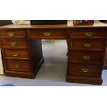 An early 20thC mahogany desk, the top set with a tooled brown hide scriber,