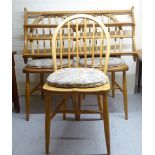 A set of three Ercol beech and elm framed, low, spindled, hoop back kitchen chairs with solid seats,