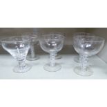 A set of five drinking glasses with wide, shallow bowls and cottontwist stems and a similar glass,