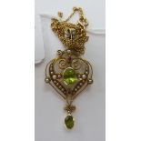 A gold coloured metal framed, seed pearl and peridot set pendant,