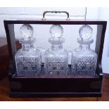A modern brass mounted mahogany tantalus 12''h 15''w with three cut glass decanters of shouldered