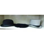 Two Moss Bros hats, viz. a black bowler hat size 7/1.8; a grey top hat size 7/2.