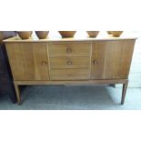 A Gordon Russell 1970s teak sideboard with a central bank of three drawers,