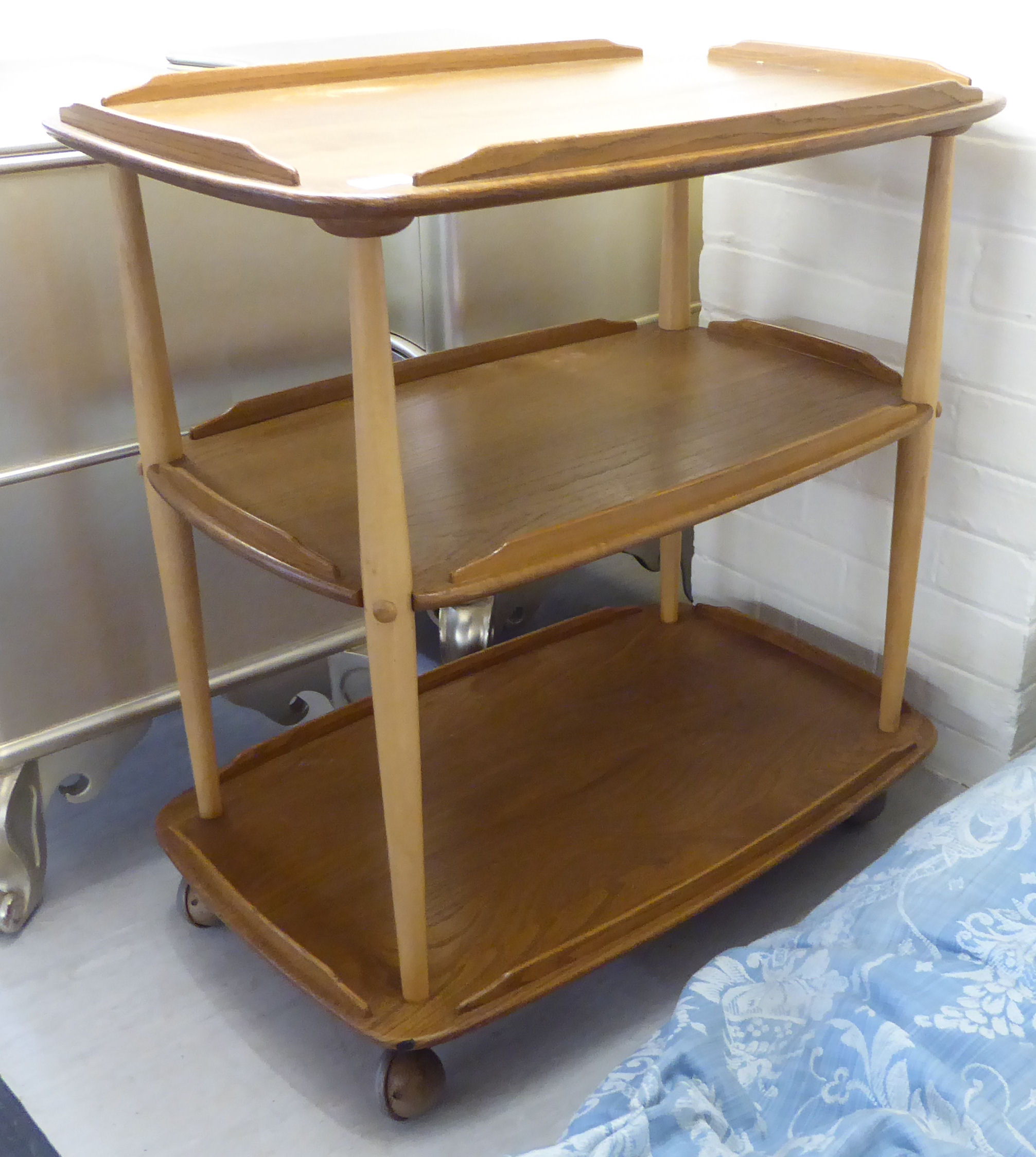 An Ercol beech and elm galleried, three tier tea trolley,