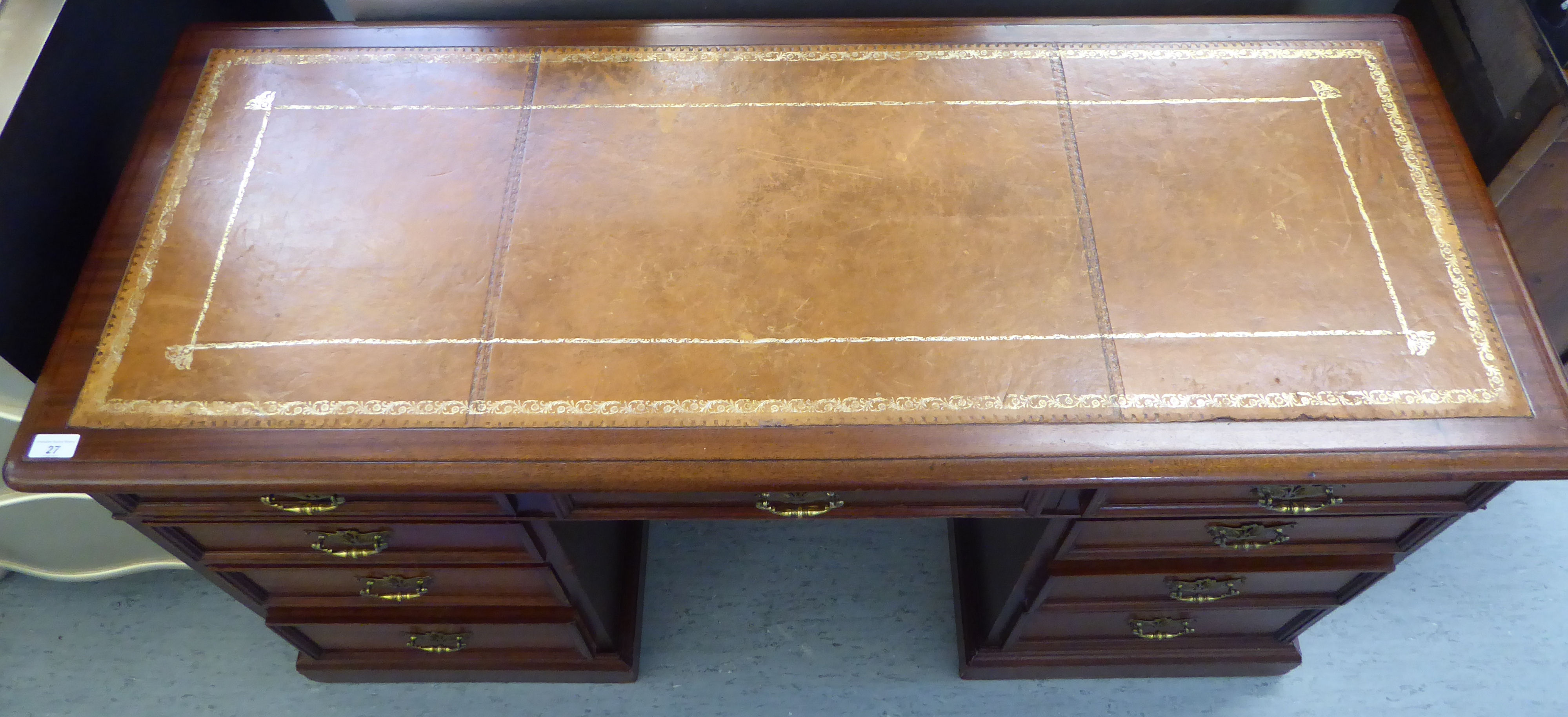 An early 20thC mahogany desk, the top set with a tooled brown hide scriber, - Image 2 of 6