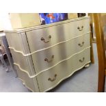 A modern silver finished, serpentine front, three drawer dressing chest with bale handles,