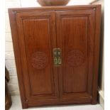 A modern Chinese fruitwood side cabinet with a pair of panelled doors,