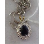 A 9ct white gold oval sapphire and diamond pendant,